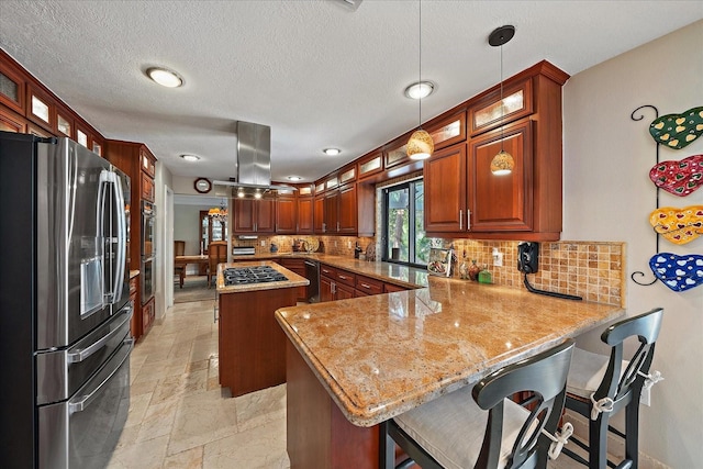 kitchen with a center island, stone tile floors, island range hood, stainless steel fridge, and a peninsula