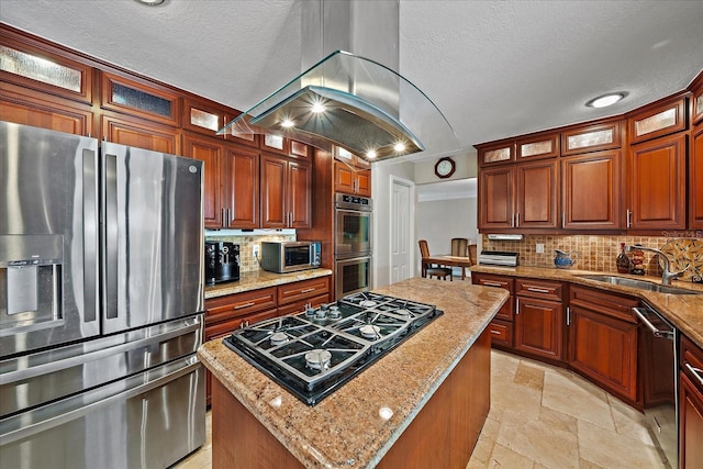 kitchen featuring stone tile floors, stainless steel appliances, tasteful backsplash, a sink, and a kitchen island