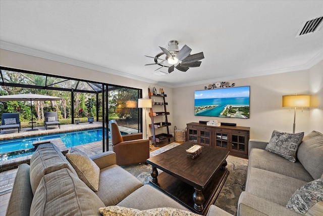 living area with wood finished floors, a sunroom, a ceiling fan, visible vents, and crown molding