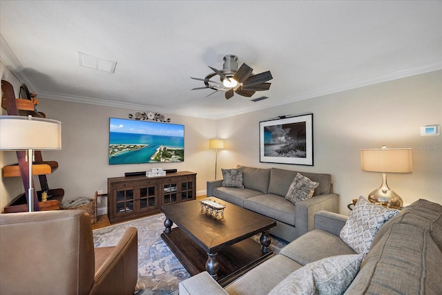 living area featuring crown molding, visible vents, a ceiling fan, wood finished floors, and baseboards