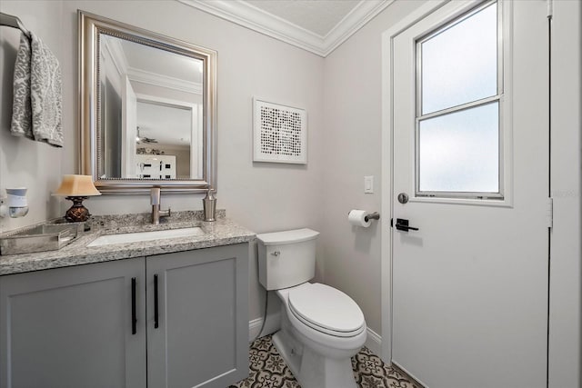 bathroom with baseboards, vanity, toilet, and crown molding