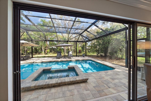 view of pool featuring a patio, a lanai, and a pool with connected hot tub