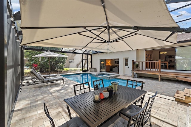 view of swimming pool with outdoor dining space, a patio area, a lanai, and a pool with connected hot tub