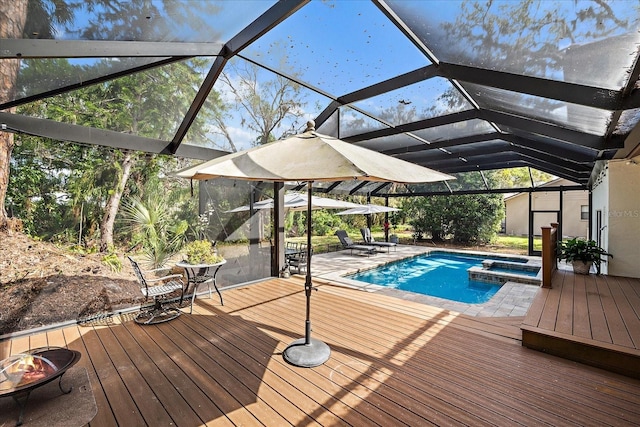 view of pool with glass enclosure, a pool with connected hot tub, and a wooden deck