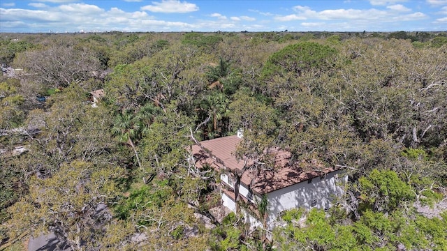 drone / aerial view featuring a wooded view