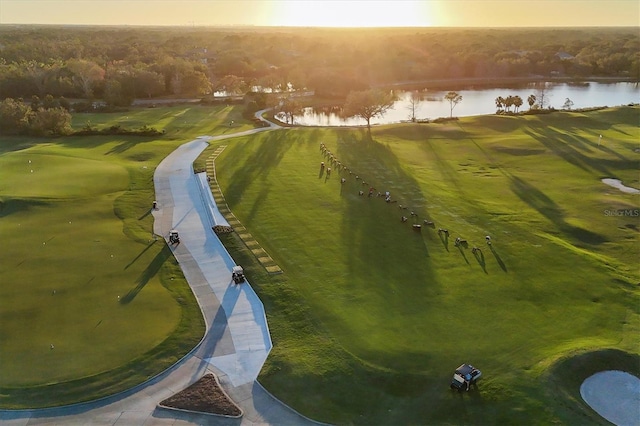 drone / aerial view with a water view and golf course view