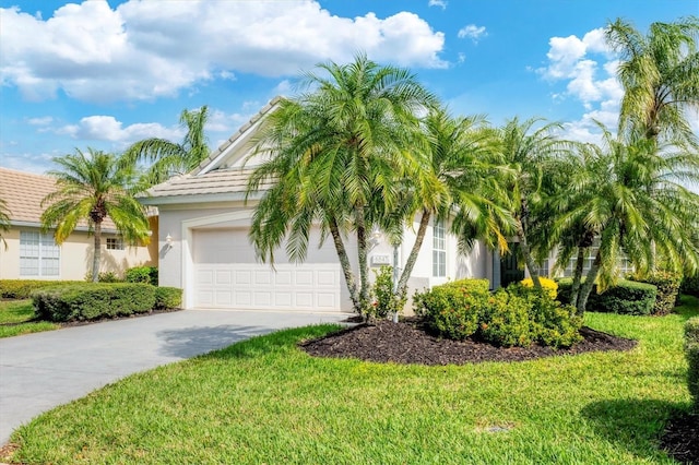 view of front of property featuring a front yard, driveway, an attached garage, and stucco siding