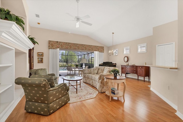 living area featuring baseboards, visible vents, lofted ceiling, wood finished floors, and ceiling fan with notable chandelier