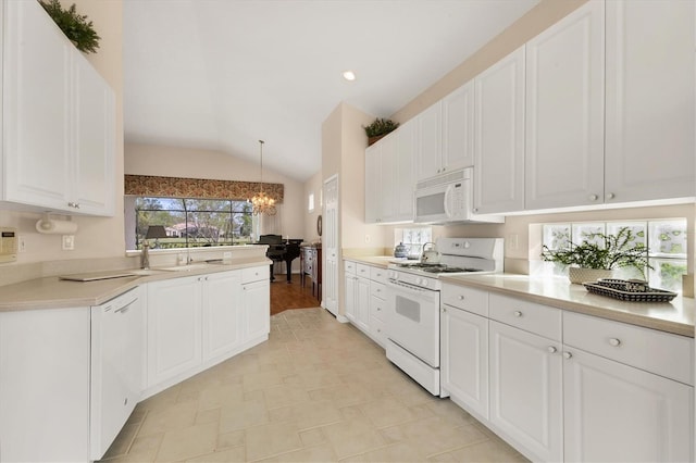 kitchen with white appliances, white cabinets, lofted ceiling, hanging light fixtures, and light countertops