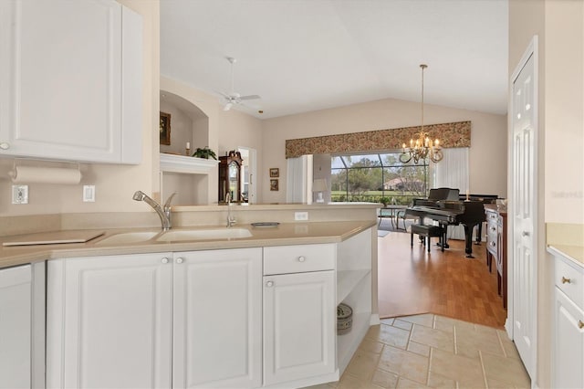 kitchen with white cabinetry, pendant lighting, light countertops, and a sink