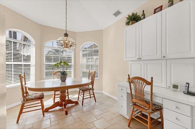 dining area featuring visible vents, baseboards, stone tile floors, and built in desk