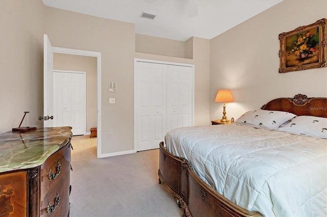 bedroom featuring baseboards, visible vents, a closet, and light colored carpet