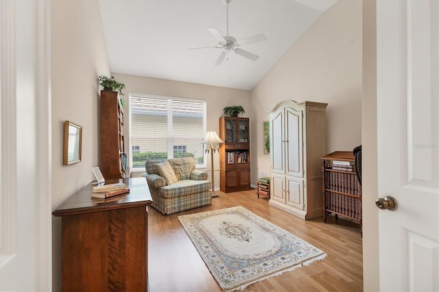 sitting room with vaulted ceiling, light wood-style flooring, and a ceiling fan