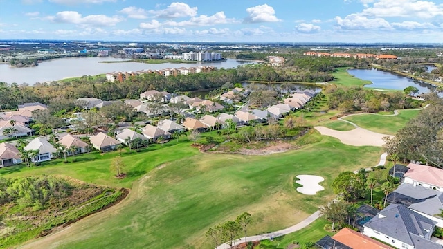 drone / aerial view with a residential view, view of golf course, and a water view