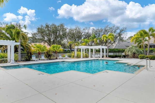 community pool with a patio area, fence, and a pergola