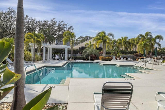 pool with a patio, fence, and a pergola