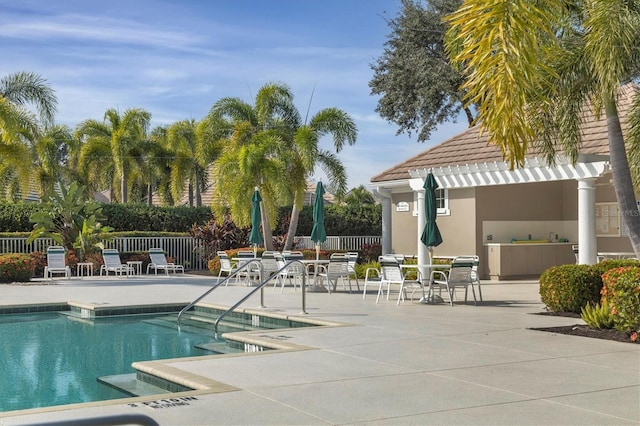 community pool featuring a pergola, a patio, and fence