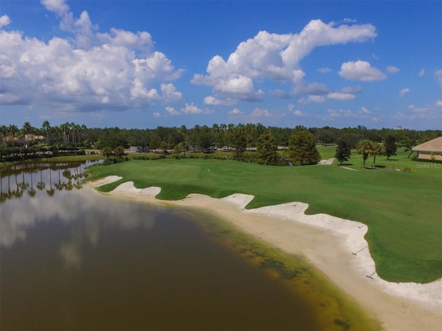 view of community with view of golf course, a water view, a yard, and dirt driveway