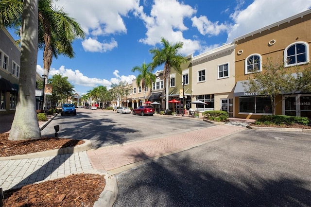 view of road featuring street lighting, a residential view, curbs, and sidewalks