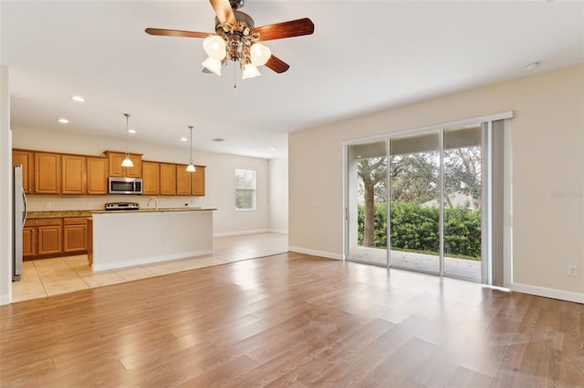 unfurnished living room with light wood-type flooring, baseboards, a ceiling fan, and recessed lighting