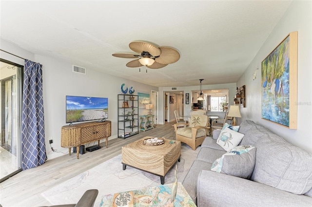 living area with light wood-style flooring, visible vents, and a ceiling fan