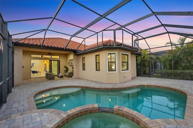 view of swimming pool featuring a ceiling fan, a lanai, a patio area, and a pool with connected hot tub