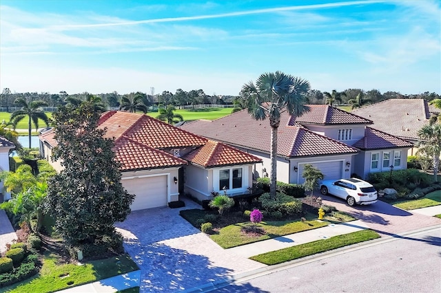 mediterranean / spanish-style home featuring decorative driveway, an attached garage, and a tile roof