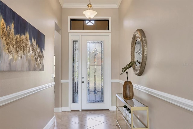 foyer featuring tile patterned flooring, ornamental molding, and baseboards