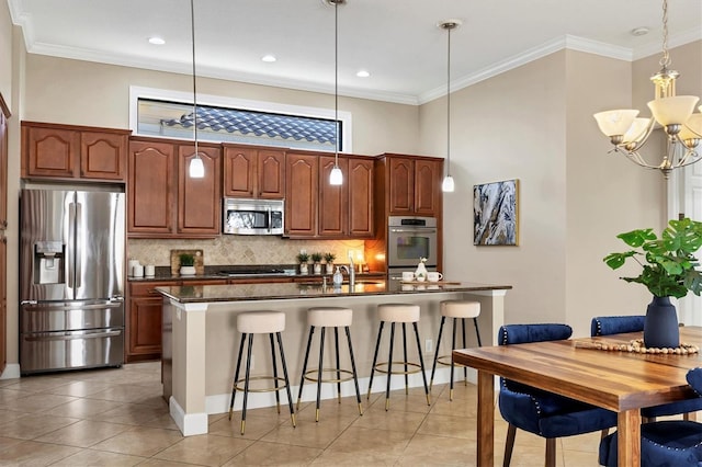 kitchen with appliances with stainless steel finishes, dark countertops, hanging light fixtures, and a breakfast bar