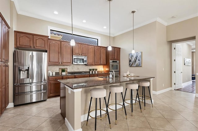 kitchen featuring light tile patterned floors, stainless steel appliances, a breakfast bar, hanging light fixtures, and an island with sink