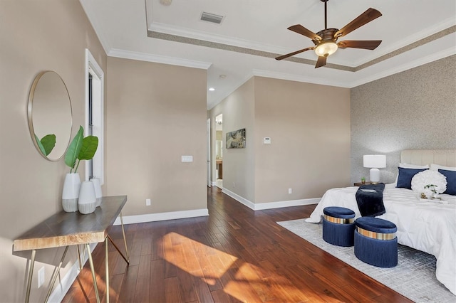 bedroom featuring dark wood-style floors, baseboards, visible vents, and a tray ceiling