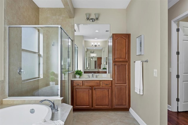 bathroom with a shower stall, vanity, a bath, baseboards, and tile patterned floors