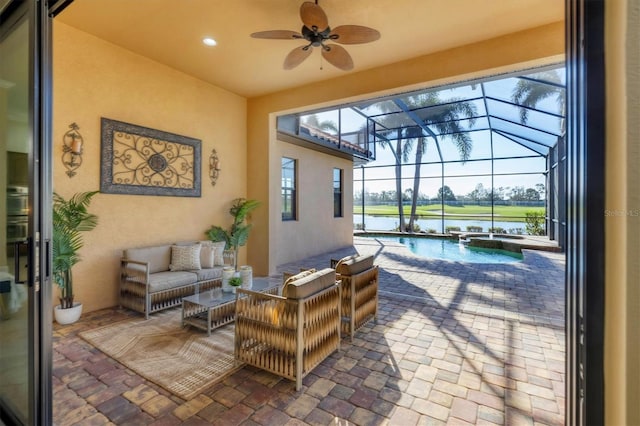 view of patio / terrace with glass enclosure, ceiling fan, an outdoor hangout area, a water view, and a pool with connected hot tub