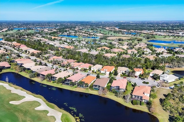 drone / aerial view with golf course view, a water view, and a residential view