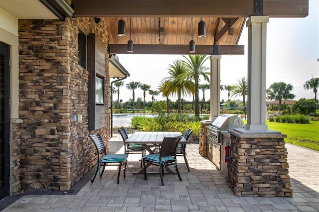 view of patio / terrace featuring outdoor dining space, a grill, and an outdoor kitchen