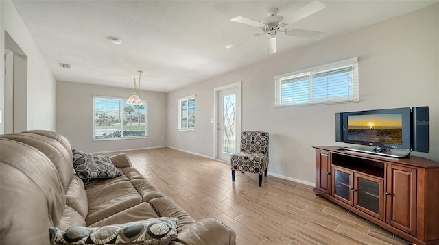 living area featuring visible vents, ceiling fan, light wood-style flooring, and baseboards