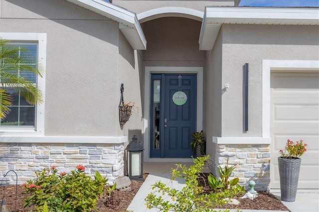 doorway to property with stone siding and stucco siding