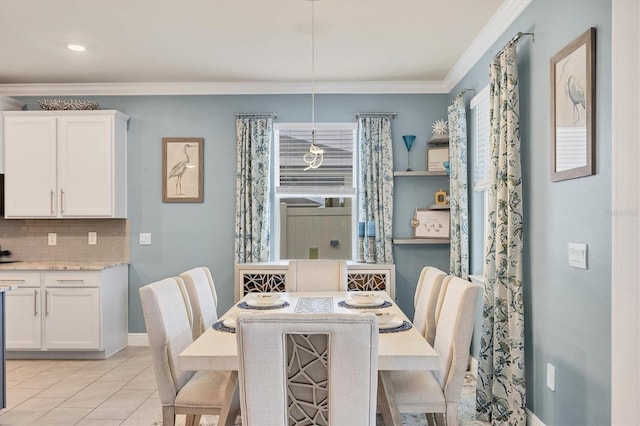 dining space with light tile patterned floors, baseboards, and crown molding