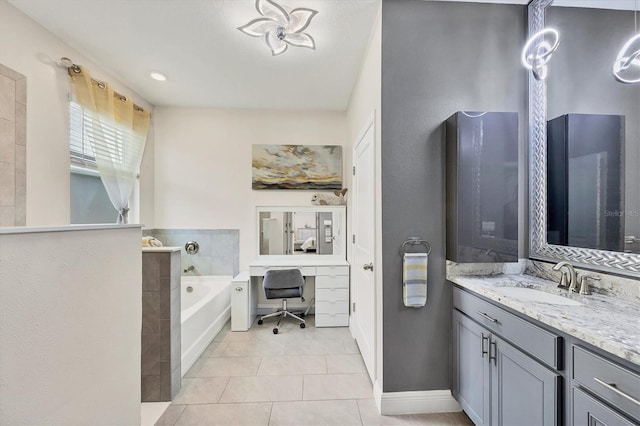 bathroom featuring baseboards, vanity, a bath, and tile patterned floors