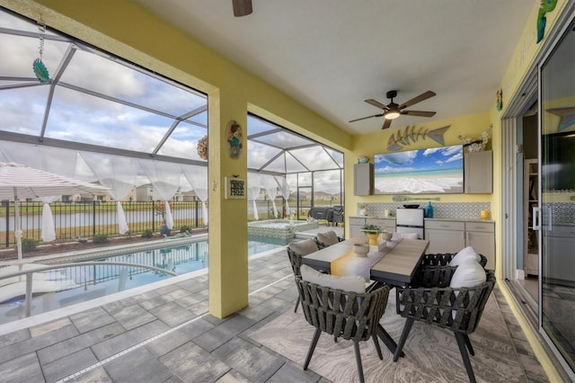 sunroom featuring a water view, a healthy amount of sunlight, and a ceiling fan