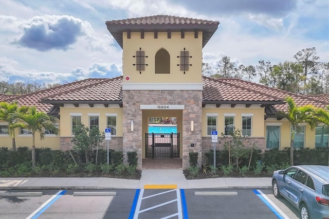 view of building exterior with uncovered parking and fence