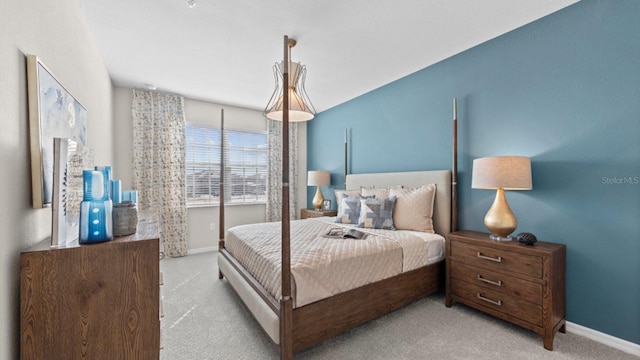 bedroom featuring light carpet and baseboards