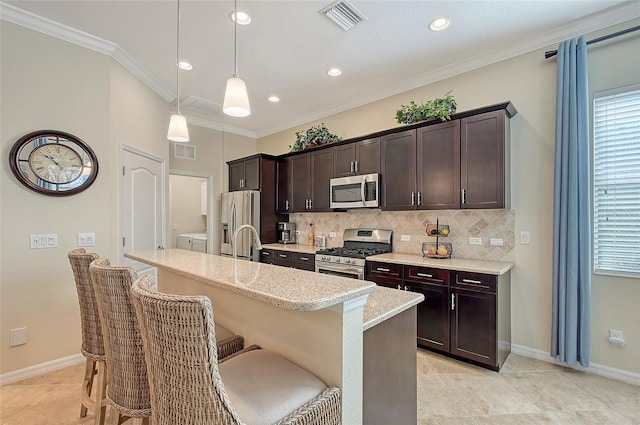 kitchen with pendant lighting, a breakfast bar area, washing machine and clothes dryer, visible vents, and appliances with stainless steel finishes