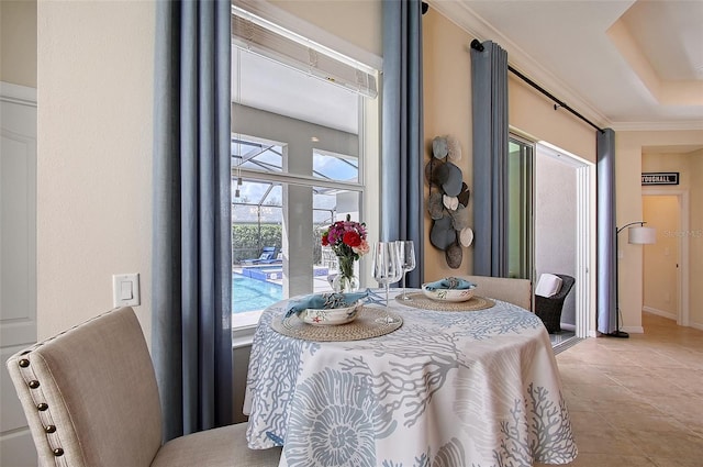 dining space featuring light tile patterned floors, ornamental molding, and baseboards