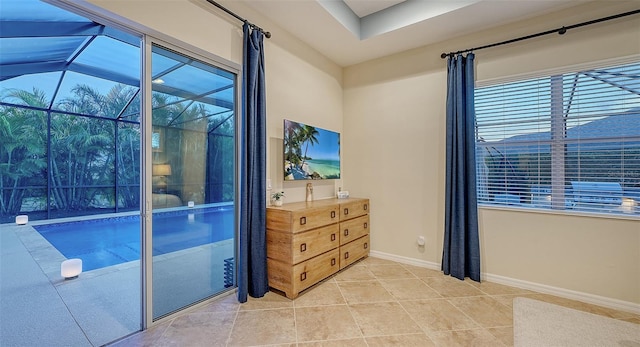 interior space with a sunroom, light tile patterned floors, and baseboards