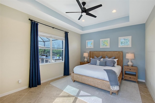 bedroom featuring light tile patterned floors, baseboards, a raised ceiling, and recessed lighting