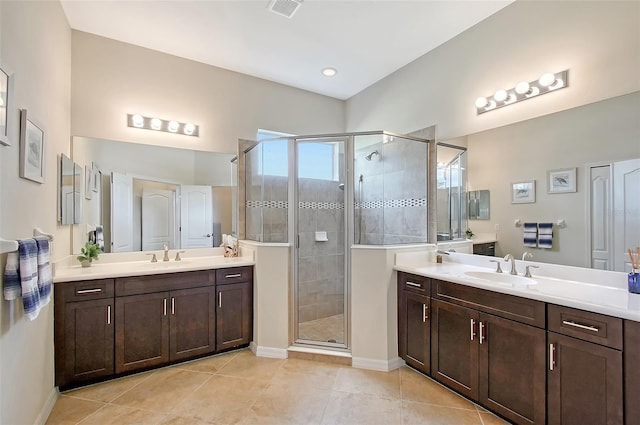 full bathroom featuring tile patterned floors, two vanities, a sink, and a shower stall