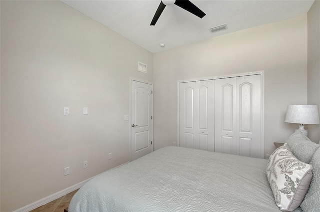 bedroom with ceiling fan, visible vents, baseboards, a closet, and tile patterned floors