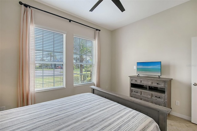 bedroom featuring light tile patterned floors, a ceiling fan, and baseboards