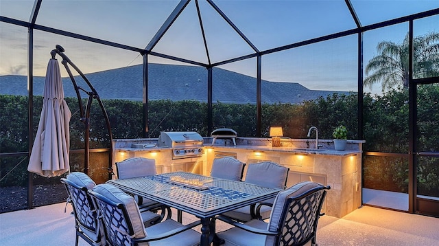 view of patio featuring a lanai, a sink, grilling area, and area for grilling